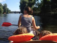 Fast alle Menschen bewegen sich gern in der Natur. Eine Frau mit zwei Kindern paddelt durch einen Fluss.