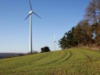 Windräder produzieren nachhaltigen Strom. Windräder auf grünen Feldern