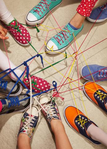 Bunte Kinderturnschuhe vernetzen sich über Schnürsenkel