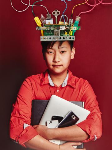 Ein Junge mit einer Krone aus Kabeln und Computertechnik auf dem Kopf