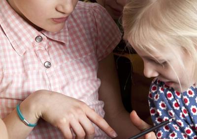 Drei Mädchen schauen auf ein Tablet