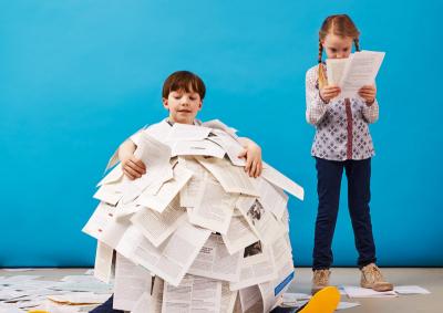 Ein Junge ist mit hunderten von Seiten bedeckt, ein Mädchen steht daneben