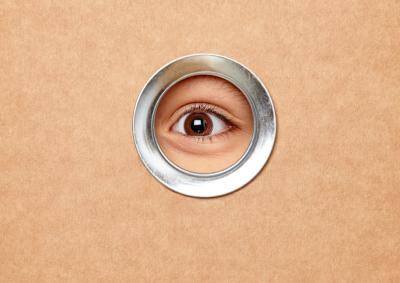 Ein Auge blickt durch ein Guckloch
