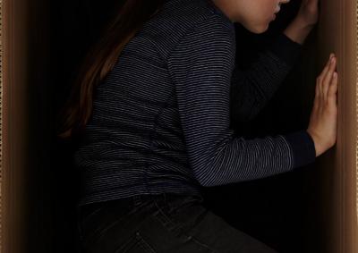 Mädchen blickt durch ein Loch in der Wand