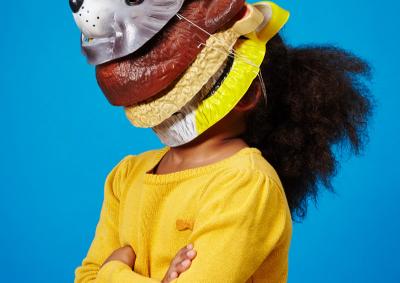 Ein Kind mit vielen Masken übereinander